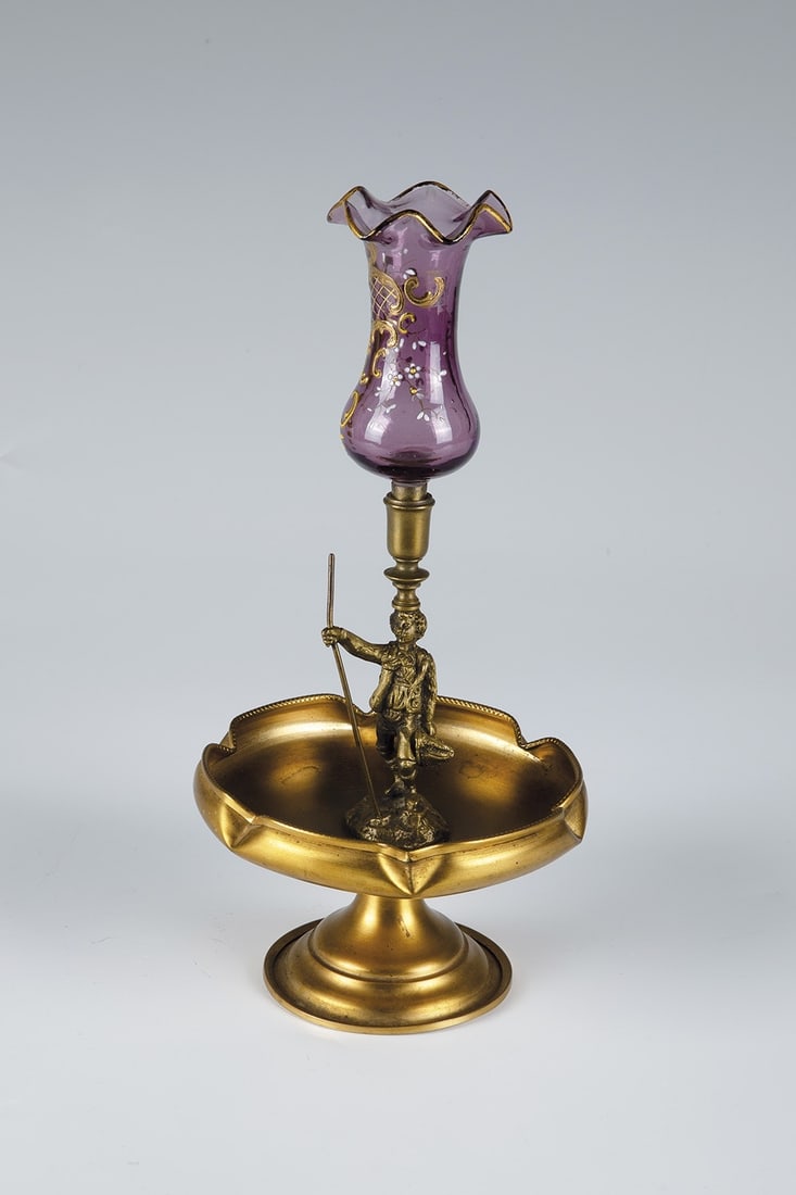 Tazza with attachment: Tazza with top Bohemia, c. 1900 Tazza made of brass-coloured metal. Six-fold pressed wall. Centrally mounted figure of a wanderer, crowned with a goblet-shaped vase top made of purple, optically