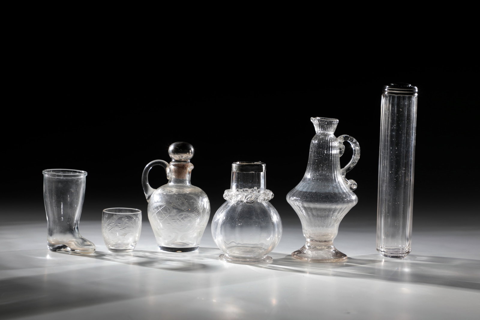 Mixed Lot of Six Glasses: Mixed lot of six glasses England 18th/19th century Consisting of: small jug with cut decoration and silver-mounted stopper. h. 10 cm; Small vase, longitudinally optically blown with wavy thread suppor