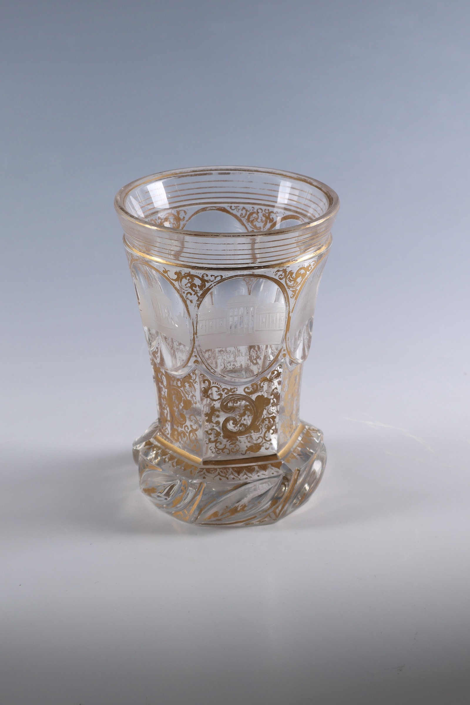 Mug with views of Mariánské Lázn?: Goblet with views of Marienbad Bohemia, c. 1840 Colourless, faceted glass with area-filling gold tendril decoration. Cantilevered edge with turban cut. Circumferential in six oval medallions five cut