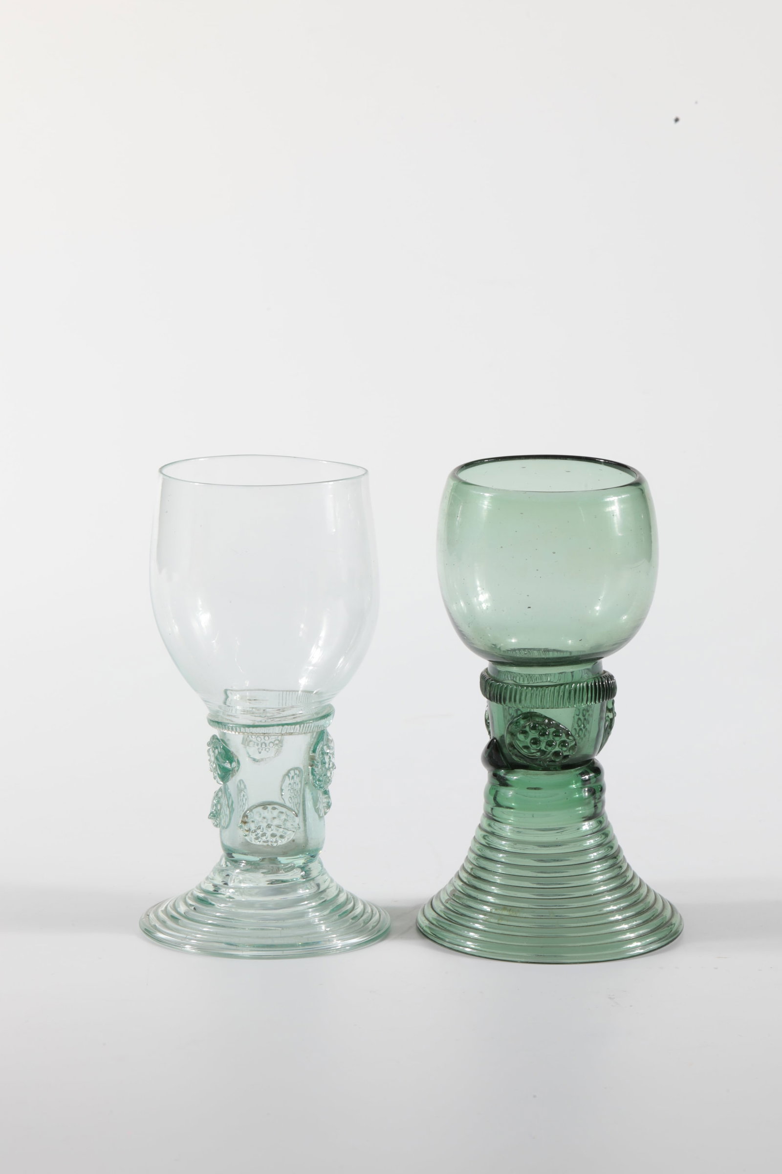 Two Romans: Two Romans German, 18th / 19th century Green glass with demolition. Ribbed trumpet foot. Berry nubs applied to the shaft, which is open at the top. Below the bulbous cuppa, a pinched thread placed all