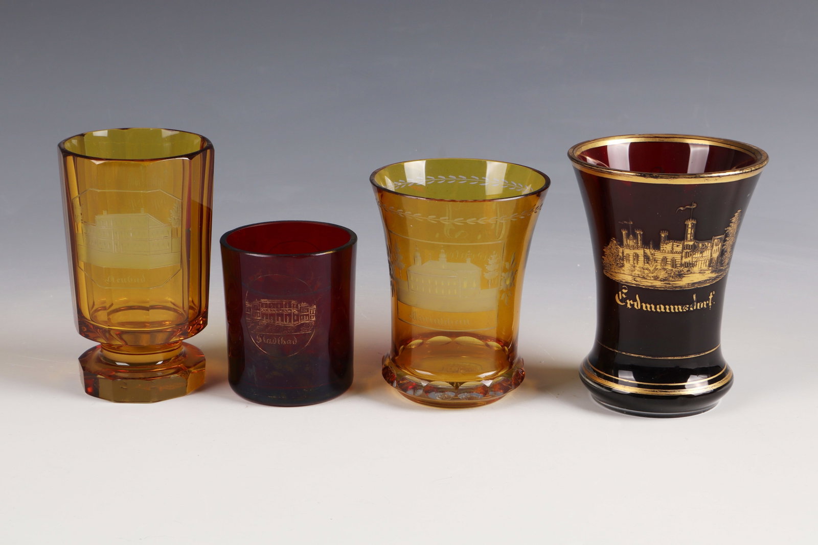 Four Cups: Four cups Bohemia, 2nd half of the 19th century Colourless, partly red or yellow glazed glass with cut, partly gilded, views of Teplice (three cups) and Erdmannsdorf. At the lip edge or stand partly