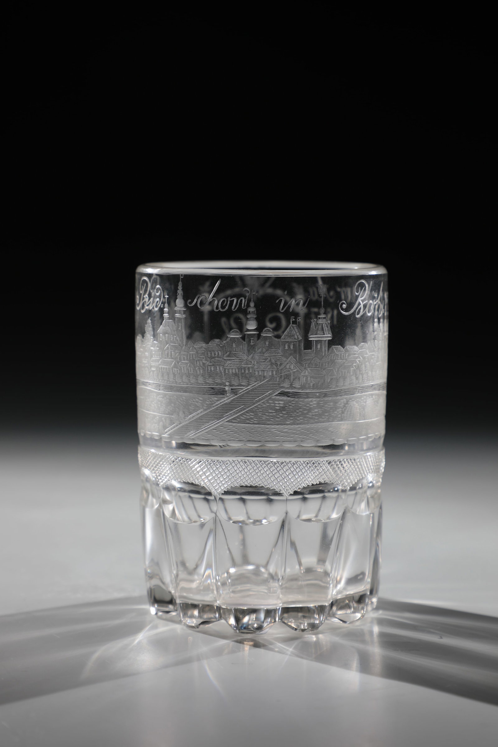 Mug with a view of Nový Bydzov: Beaker with a view of Nový Bydzov Bohemia, dated 1817 Colourless glass. Approach of the cylindrical wall with roller, lens and hatching grinding. Frontal finely cut view with inscription: ''Neu