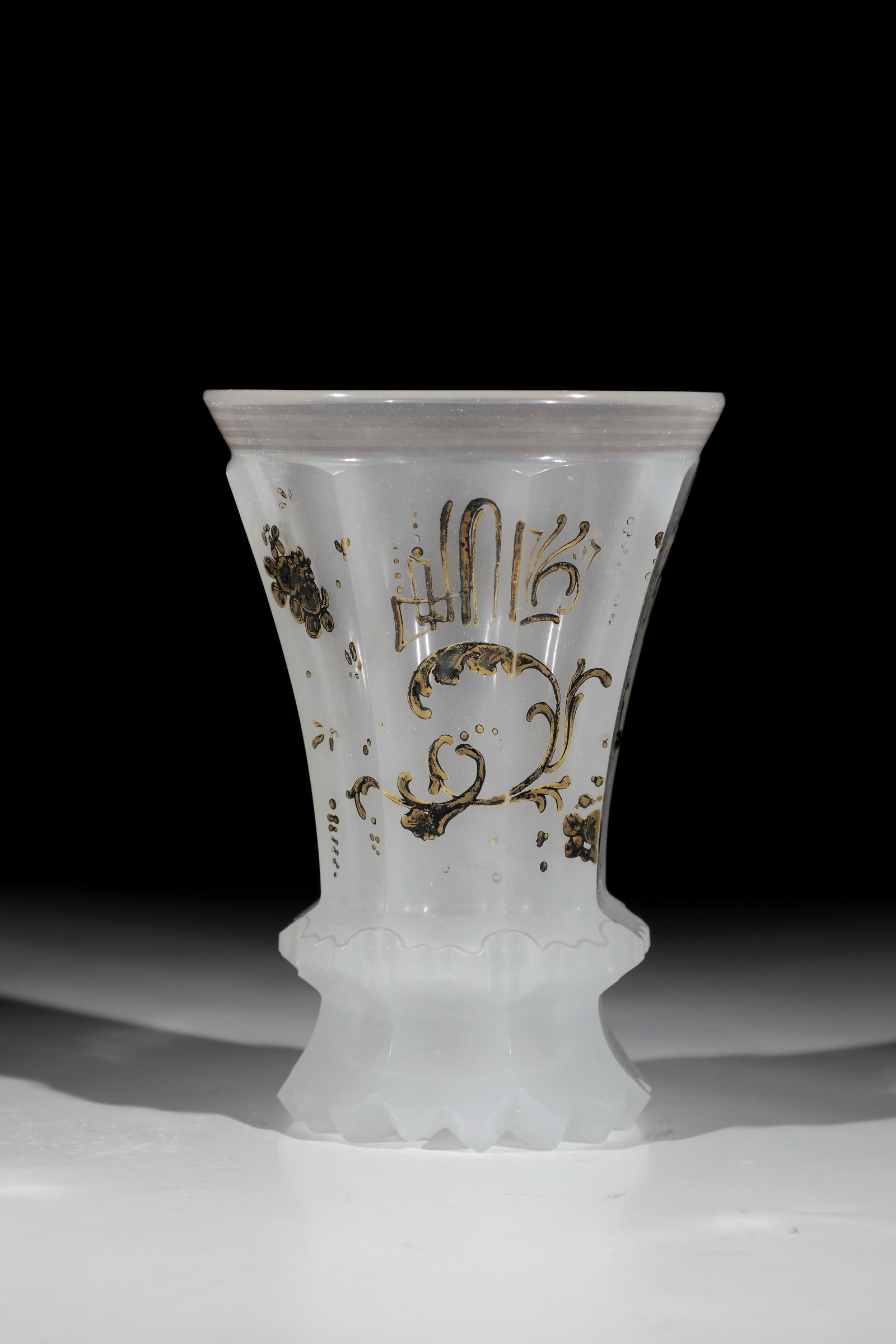 Alabaster Cup: Alabaster beaker Bohemia, M. 19th century White alabaster glass. Notched back, passingly polished Ranft. On the multi-faceted, slightly protruding wall, rocailles and C-scrolls in silver painting run