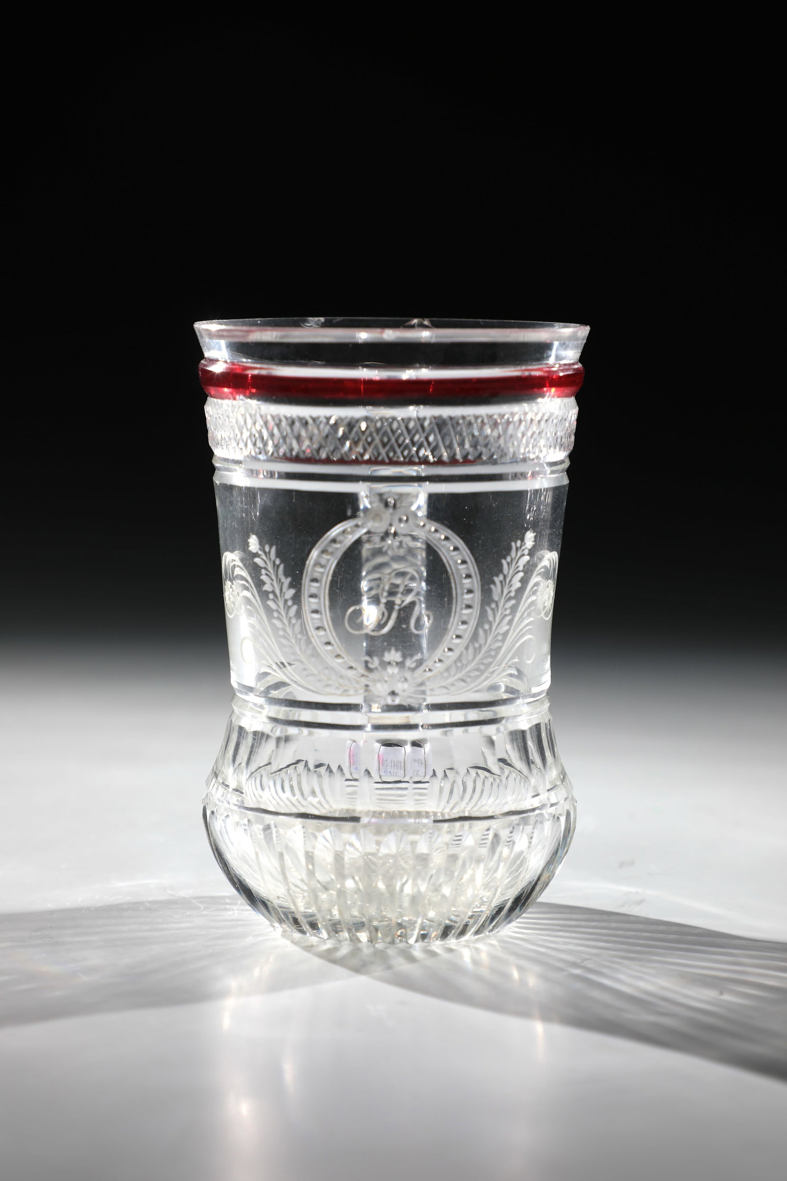 Monogram mug: Mug with monogram Giant Mountains, 2nd half of the 19th century Colourless, richly cut glass. Frontal round medallion with the initials ''JR'' flanked by floral decoration. Below the chipped lip edge 