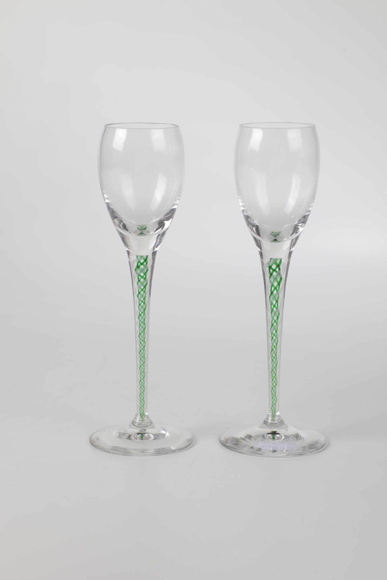 Pair of liqueur glasses: Pair of liqueur glasses probably Josephinenhütte, Schreiberhau, c. 1900 Colourless glass. Slightly conical shaft with melted white and green filigree threads in a spiral pattern. H. 15 cm each.