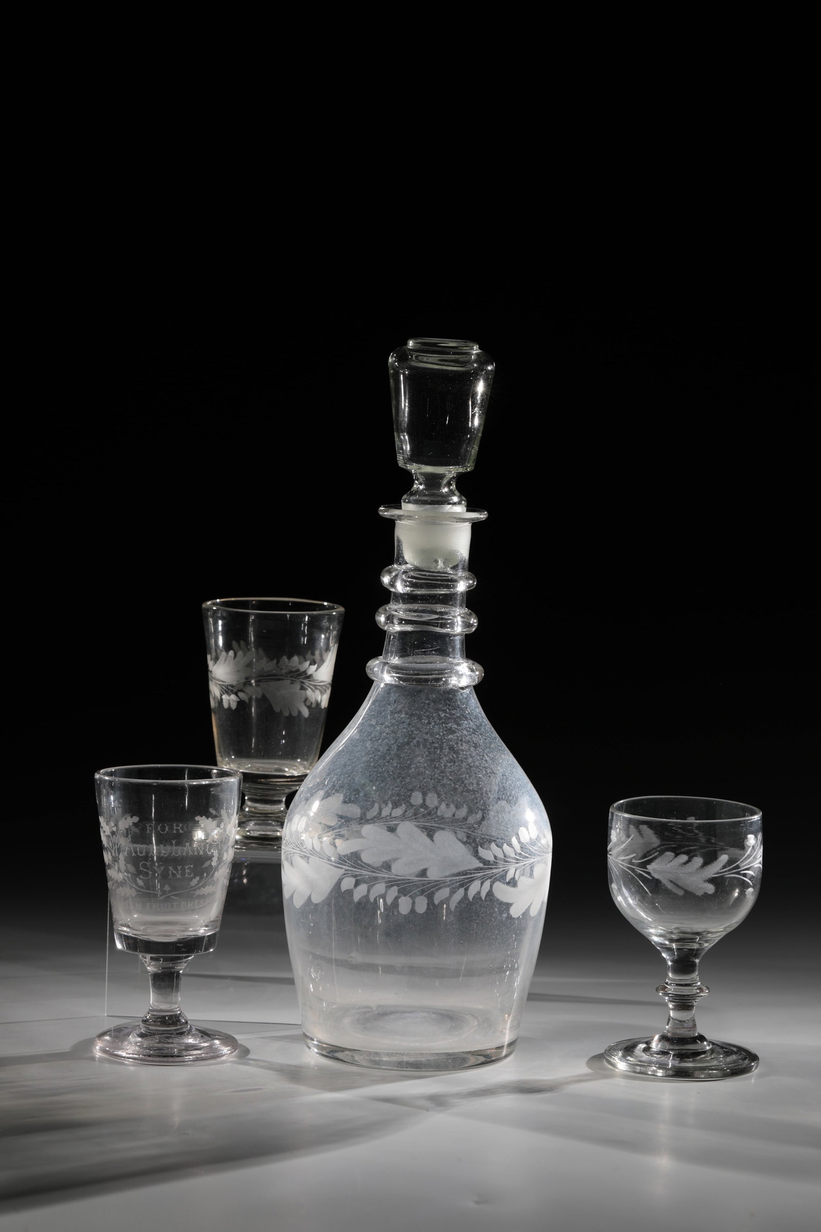 Carafe with stopper and three foot cups: Carafe with stopper and three foot cups, 19th century, colourless glass. Walls with all-round oak leaf decoration. H. 11.5 - 32 cm Karaffe mit Stöpsel und drei Fußbecher 19. Jh. Farbloses Gl