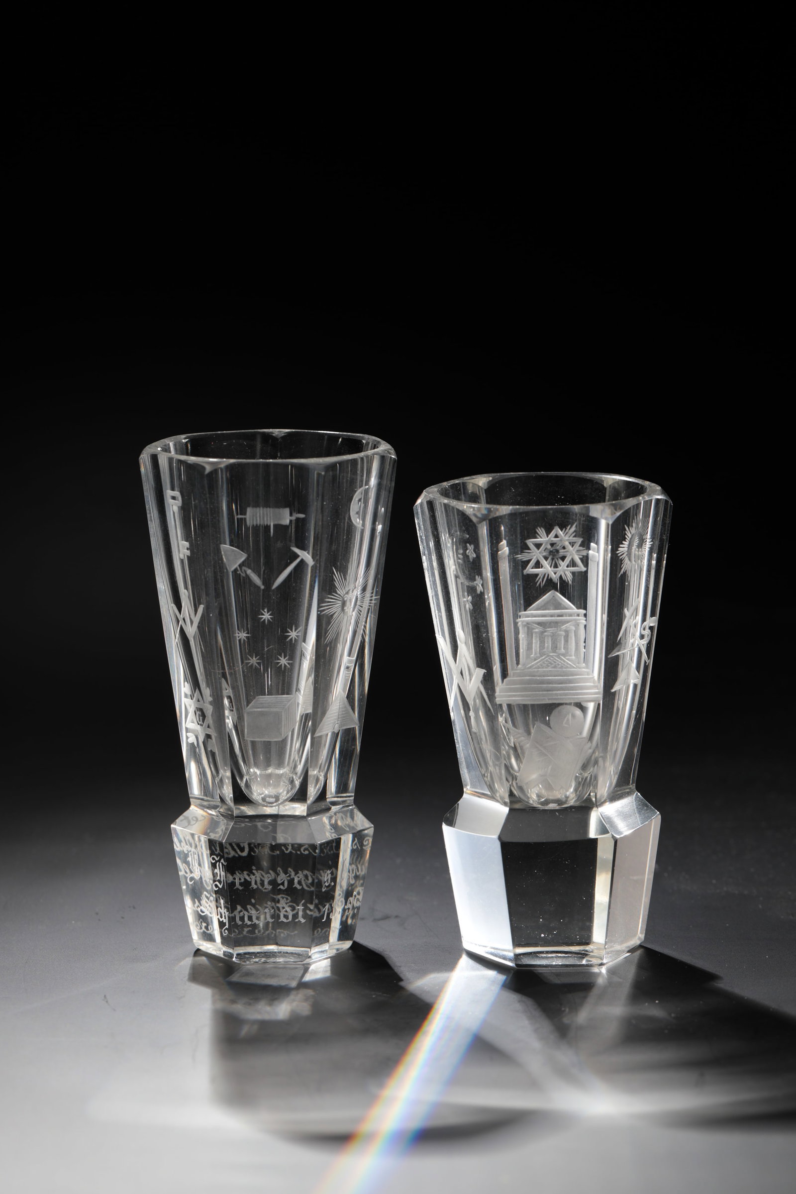 Two Masonic cannons: Two Masonic cannons German, dated 13.9.1913 Colourless, multi-faceted glass with cut Masonic symbols in matt and blank cut. H. 12 or 13 cm Zwei Freimaurer-Kanonen Deutsch, datiert 13.9.1913