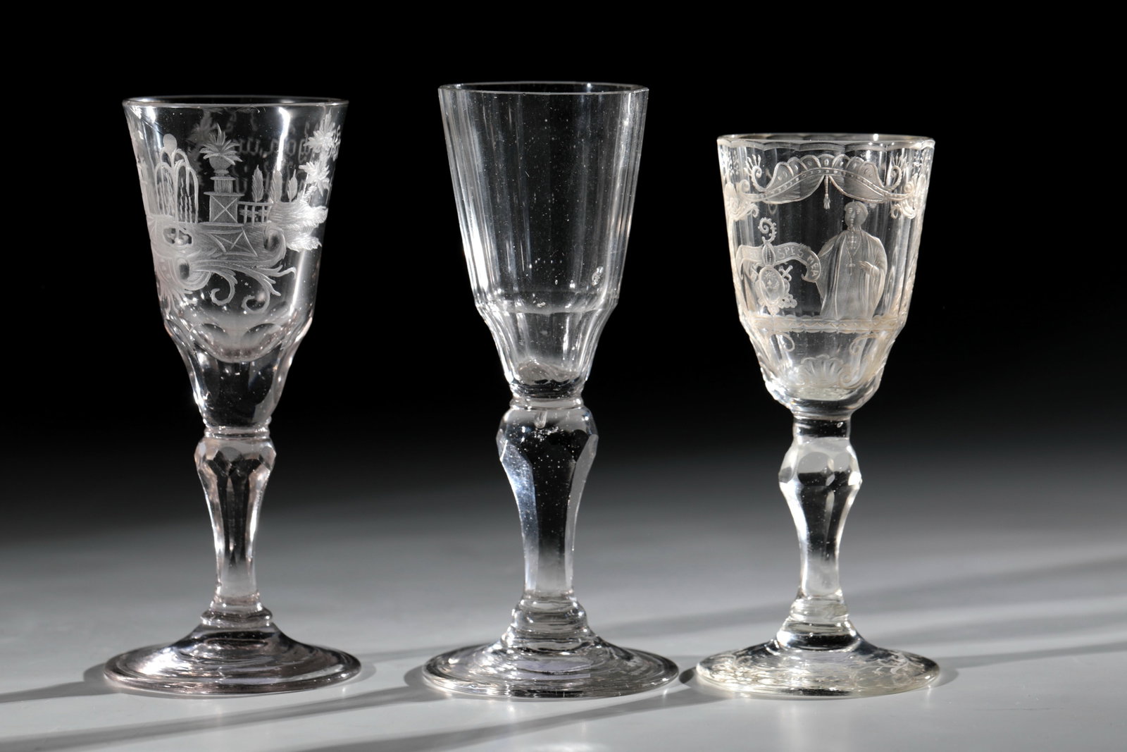 Mixed lot of three trophies: Mixed lot of three goblets Silesia, 18th century, okal with allegory of beauty Silesia, 18th century, disc base with polished outline. Baluster shaft and base of the bell-shaped cuppa faceted.
