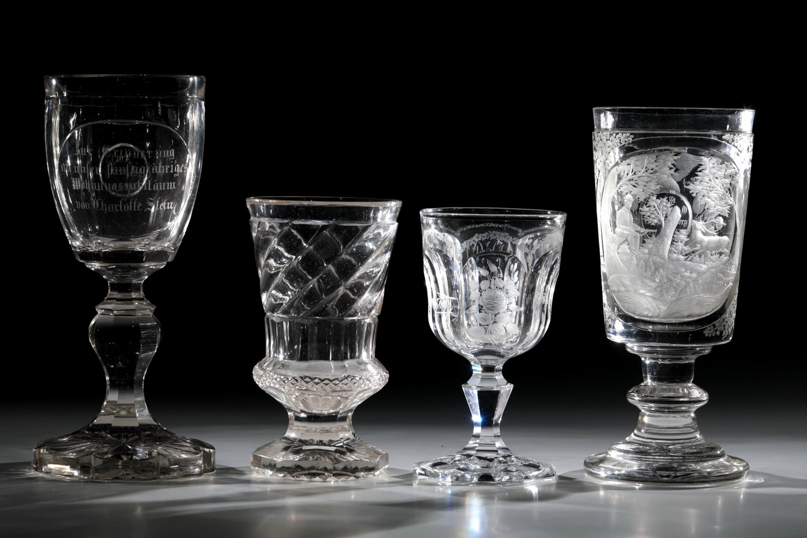 Mixed lot of four trophies: Mixed lot of four cups, 19th century, colourless glass with rich roller, hatching, depth and matt cut: hunting scene, inscription and floral decoration. H. 16.5 - 24.5 cm Konvolut vier Pokale 19. Jh.