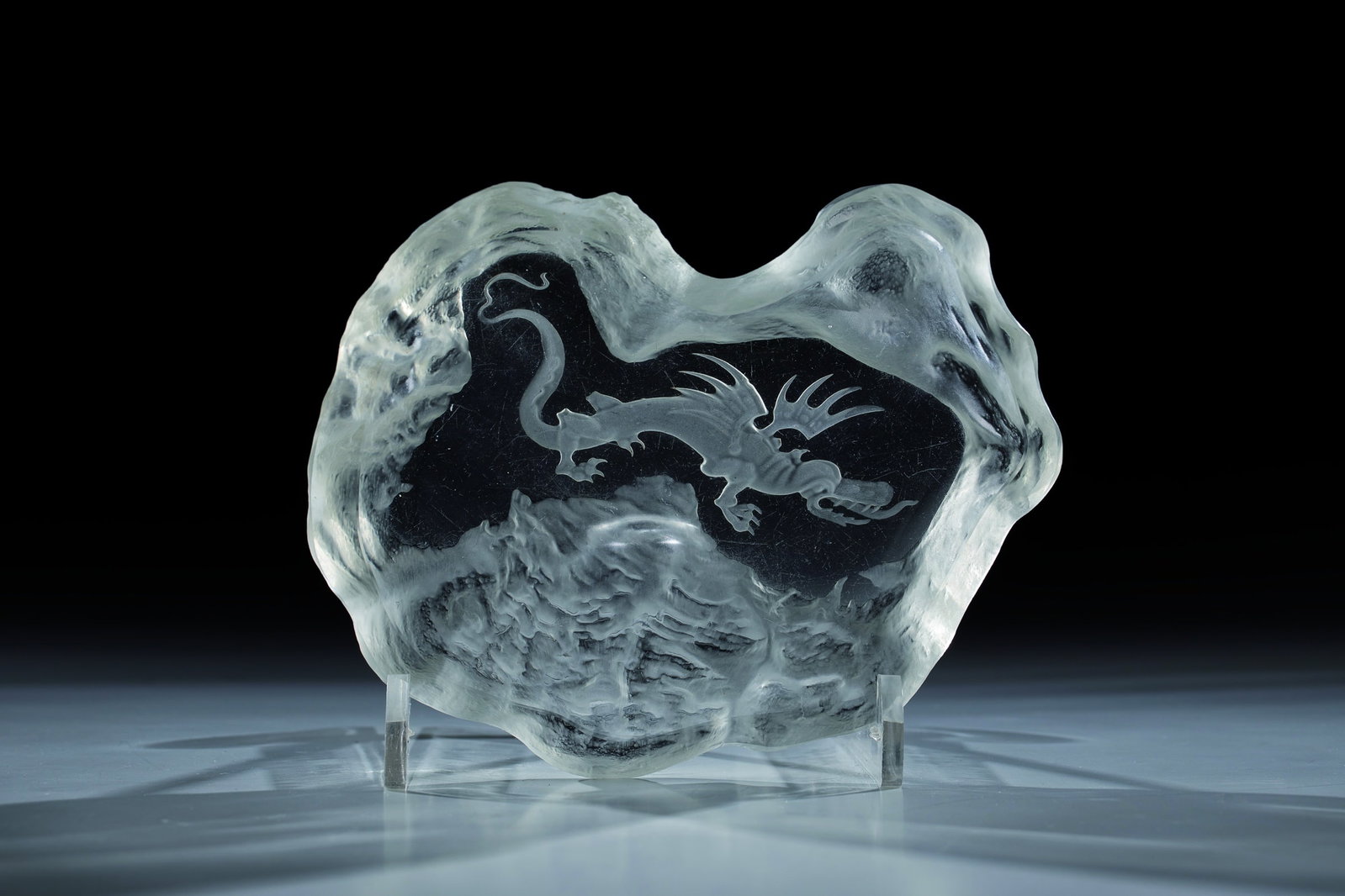 Shell: Bowl Heinrich Hoffmann (design), Gablonz an der Neiße, 1932-33 Colourless glass, pressed into the mould, matted and recut. In the ground a flying dragon in Chinese style. L. 16 cm. Lit.: P. Nov&#