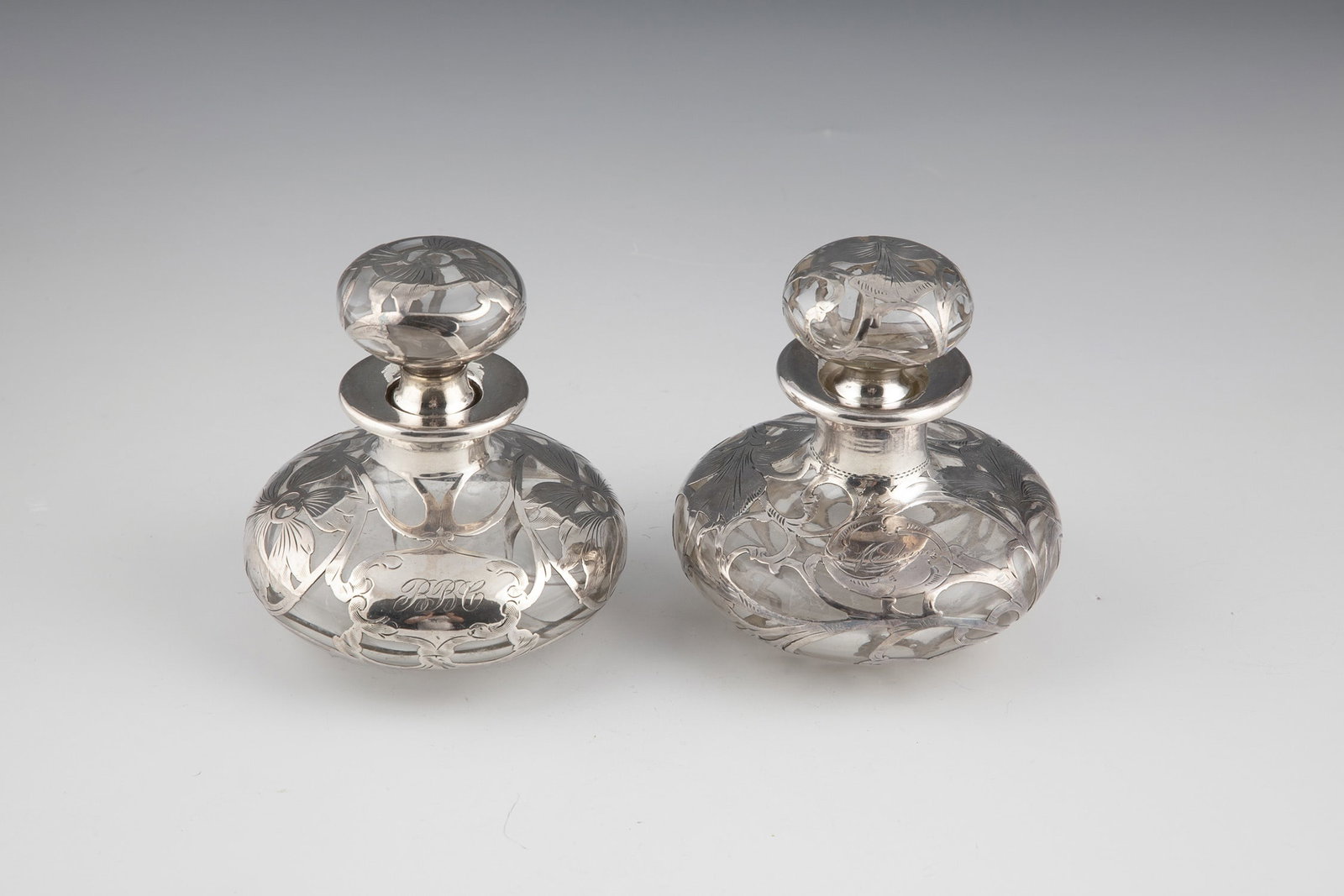 Two bottles with galvanized fine silver decoration: Two flacons with galvanized fine silver decoration Colorless glass with floral glavanized fine silver decoration and the initials ''BBC'' and the inscription ''Madeleine''. Silver stamped