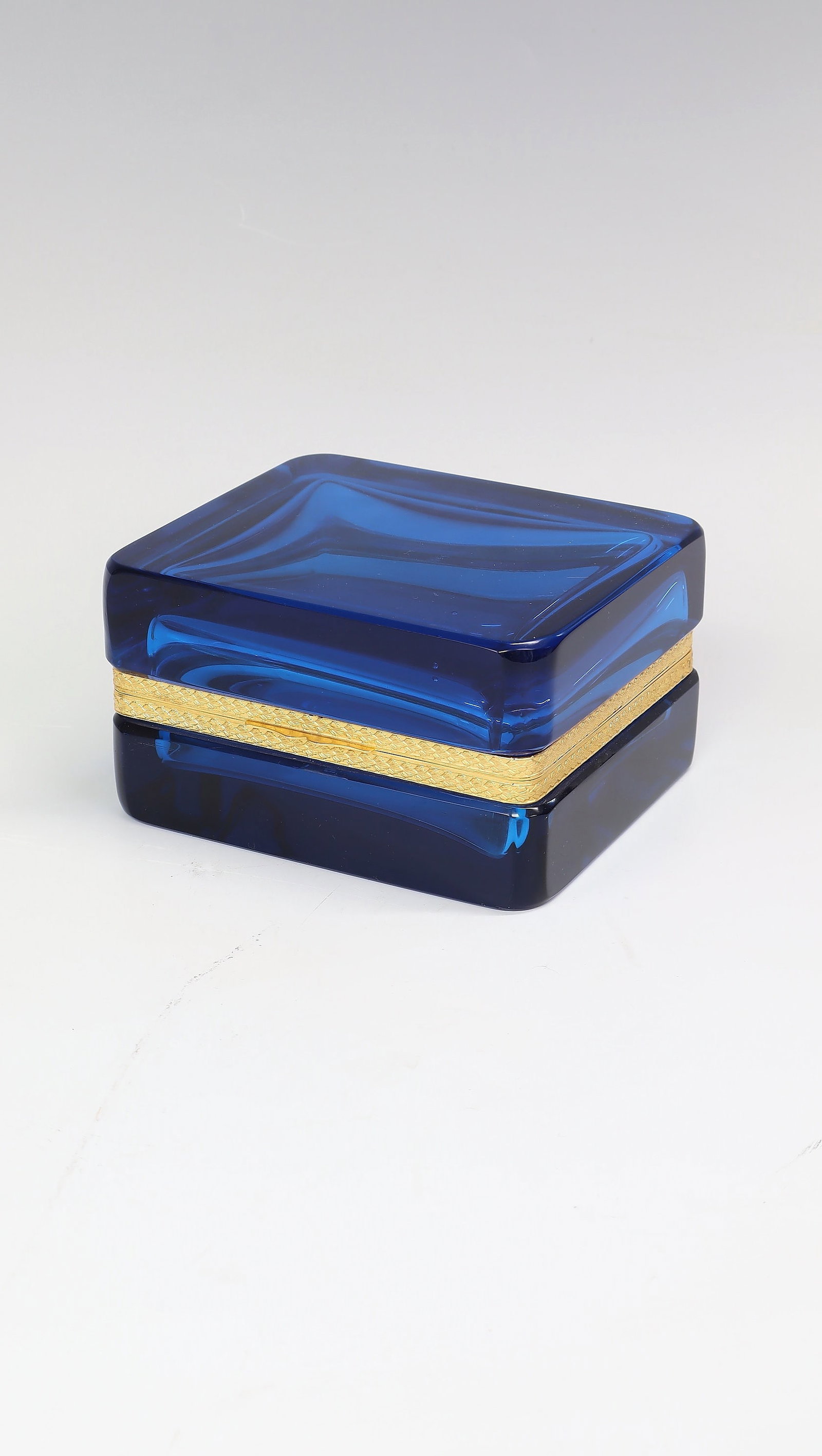 Lidded jar: Lidded box France, c. 1920 Sapphire blue glass with gold-coloured metal mount with embossed leaf decoration. H. 7.5 cm, L. 12.5 cm.