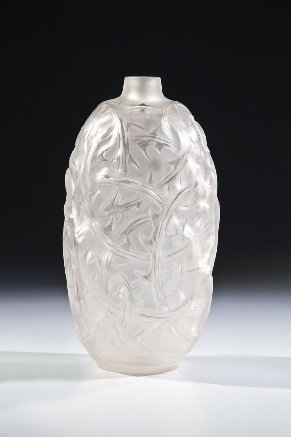 Vase ''Ronces'': Vase ''Ronces'' René Lalique, Wingen-sur-Moder, 1921 Farbloses Glas, in die Form gepresst, durch Politur nachveredelt. Umlaufender Reliefdekor: sich überlappende Brombeerzweige. H. 15,7 cm Lit.: F.