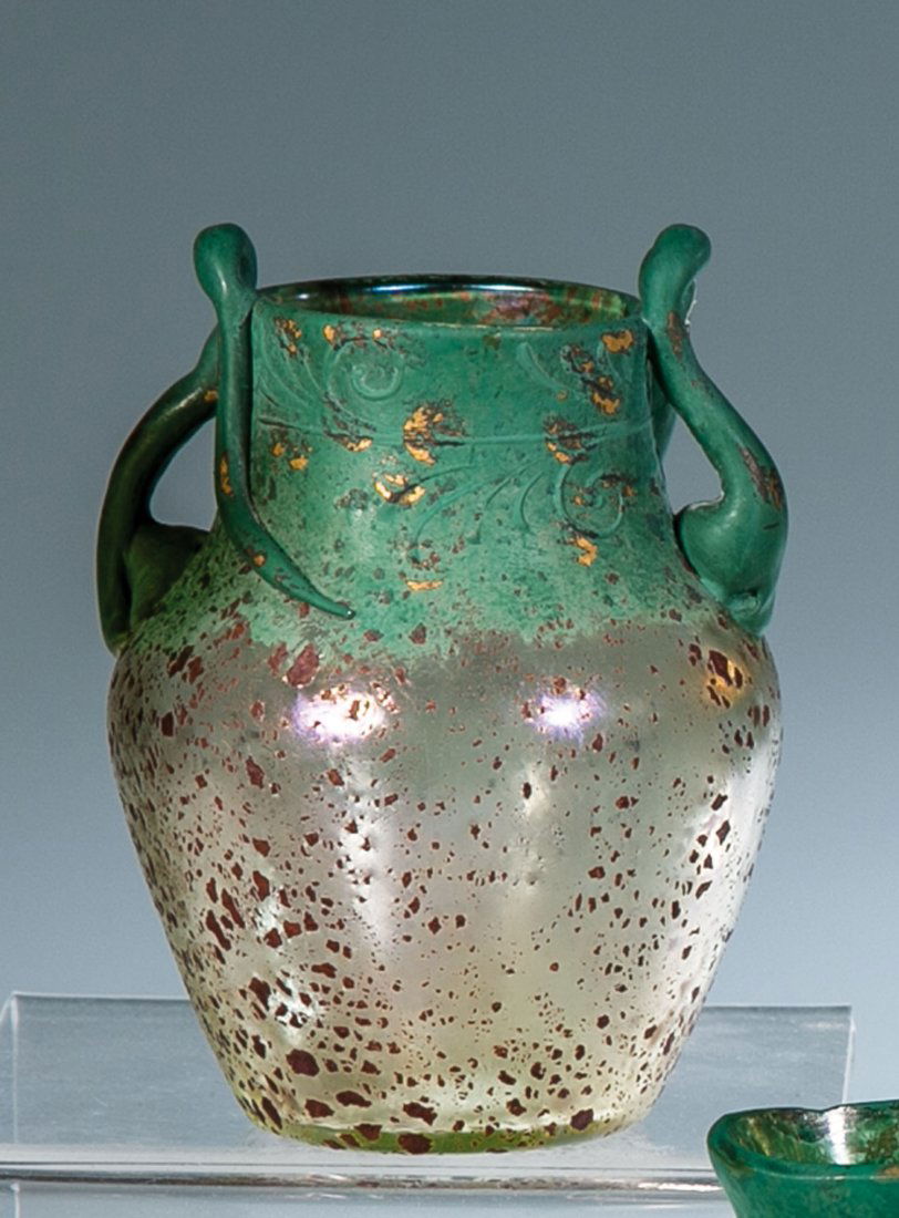 Zierhenkelvase ''Cephalonia mit Patinadekor'': Zierhenkelvase ''Cephalonia mit Patinadekor'' Loetz Wwe., Klostermühle, um 1904 Farbloses Glas mit aufgewalzter oder aufgedampfter schlackenartiger Schicht, durch Aufblasen im Model feinteilig zerris