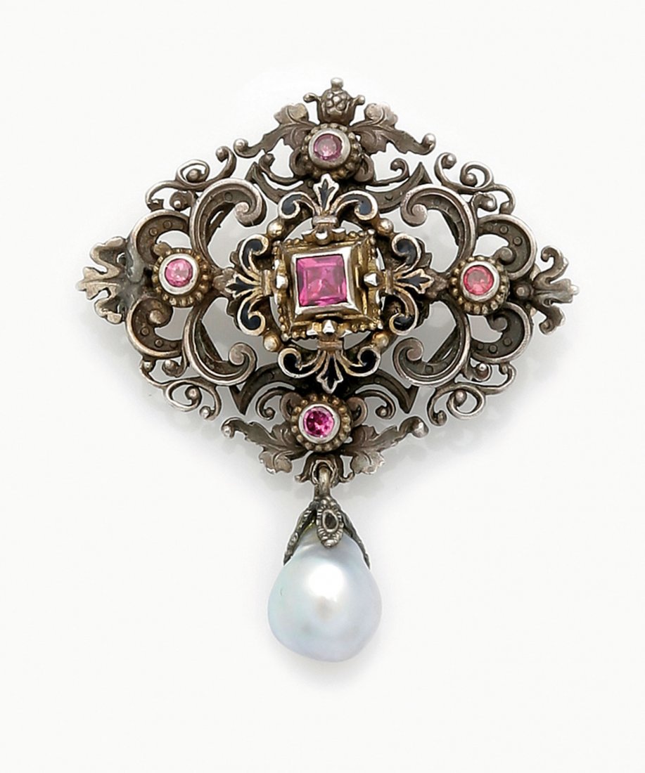 Brosche: Brosche Siebenbürgen, 19. Jh. Silber. Durchbrochene Grundplatte mit Almandinen besetzt. Zentraler Stein von Lilienornamenten mit schwarzem Email flankiert. Tropfenförmiger Perlenanhänger. L. 4 cm.