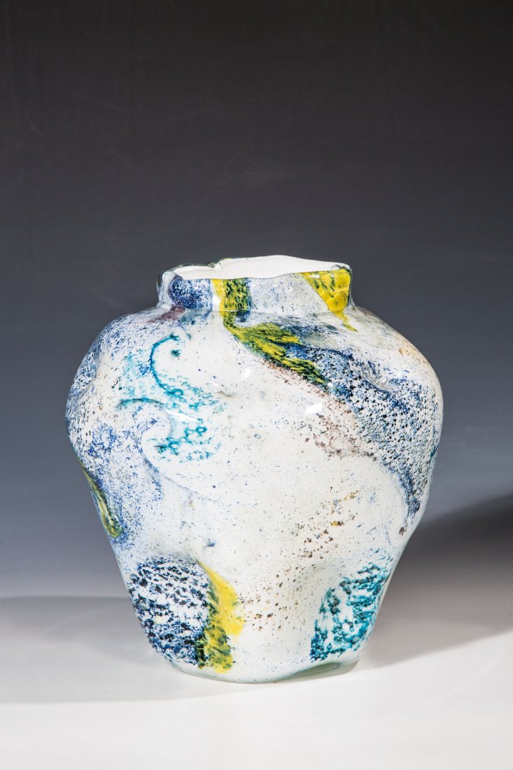 Vase: Vase Vetreria Gino Cenedese, Murano, um 1952 - 1957 Opak weißes Glas mit Aufschmelzungen von Farbglaspuder, farblos überstochen. Wandung in zwei Reihen sechsfach versetzt eingedellt. Entsprechend se
