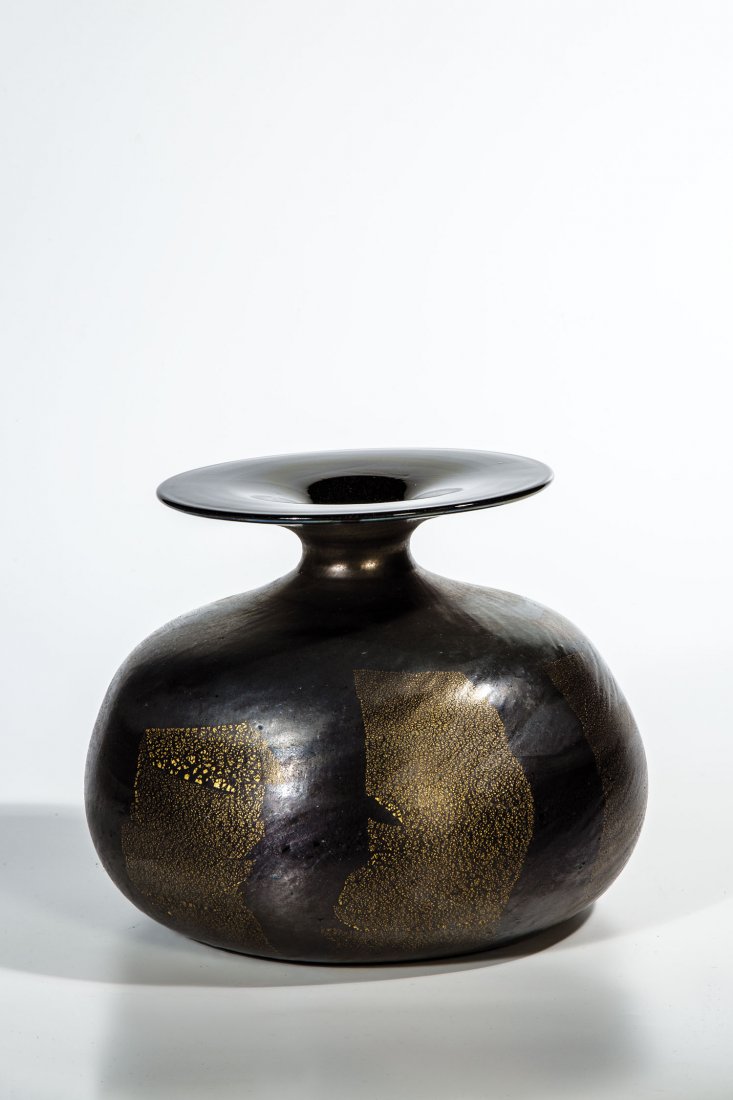 Vase ''Nerox oro'': Vase ''Nerox oro'' Ermanno Toso (Entwurf), Fratelli Toso, Murano, um 1955 ''Nerox'' - Glas mit Goldfolieneinschmelzung. Schwach metallisch irisiert. Orig.- Klebeetikett der Manfaktur. H. 20 cm Vase "N