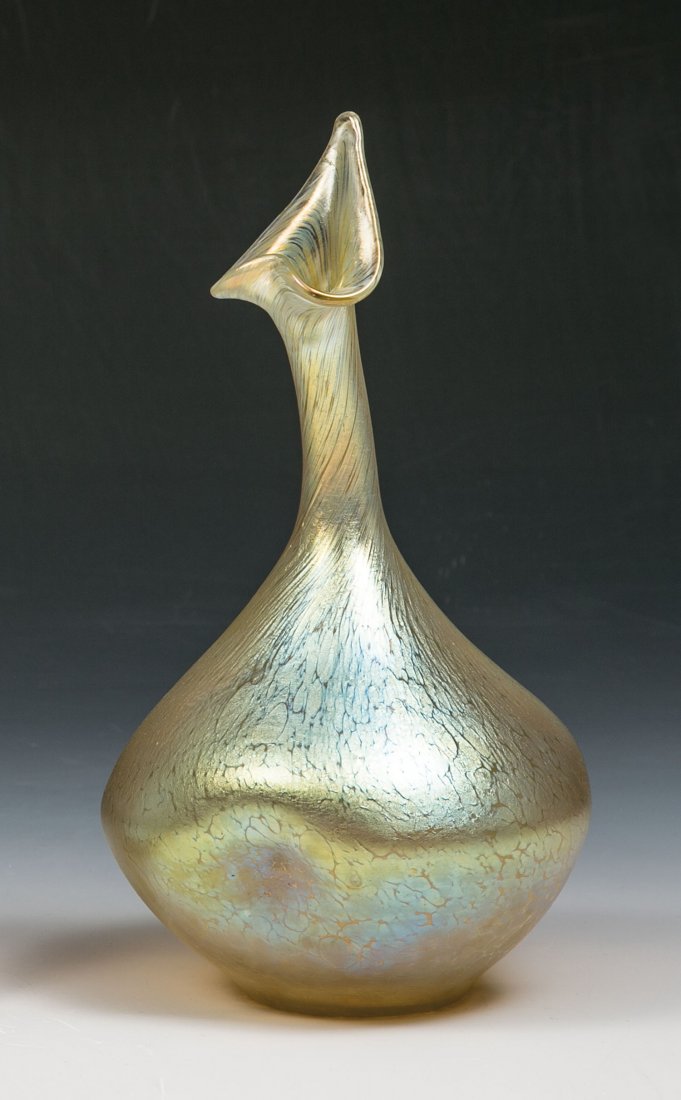 Vase in Form eines Rosensprenggefäßes ''candia: Vase in Form eines Rosensprenggefäßes ''candia papillon'' Loetz Wwe., Klostermühle, um 1900 Farbloses Glas mit eingewalzten Silbergelbkröseln. Wandung dreifach eingedellt. Matt irisiert. H. 25 cm