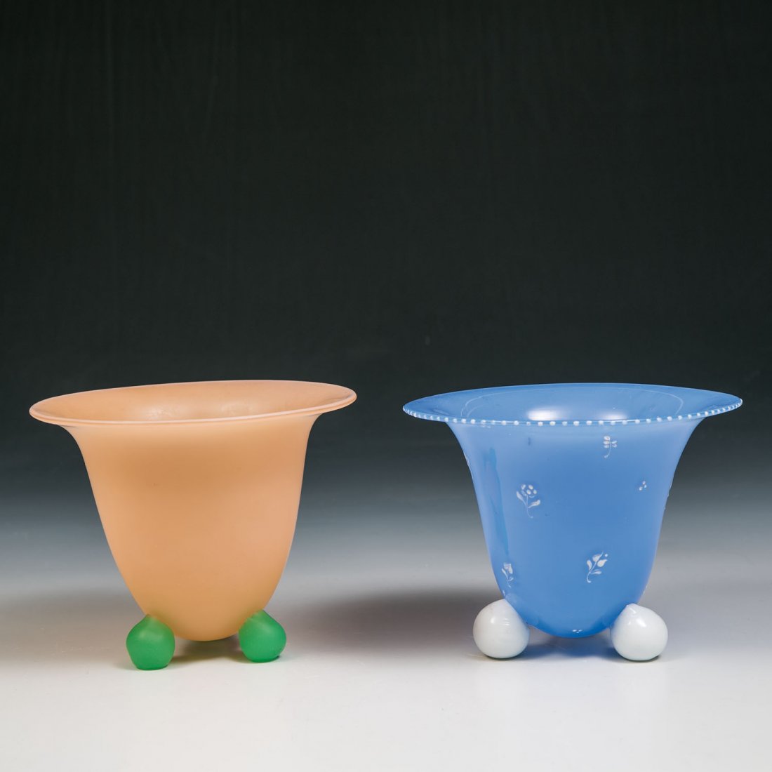 Zwei Vasen auf Kugelfüßen: Zwei Vasen auf Kugelfüßen Loetz Wwe., Kostermühle, 1915 Farbloses Glas mit Unterfängen in rosa bzw. hellblauem Opal. Eine Vase mit Streublümchendekor in weißem Opakemail. Je drei angesetzte Fü�