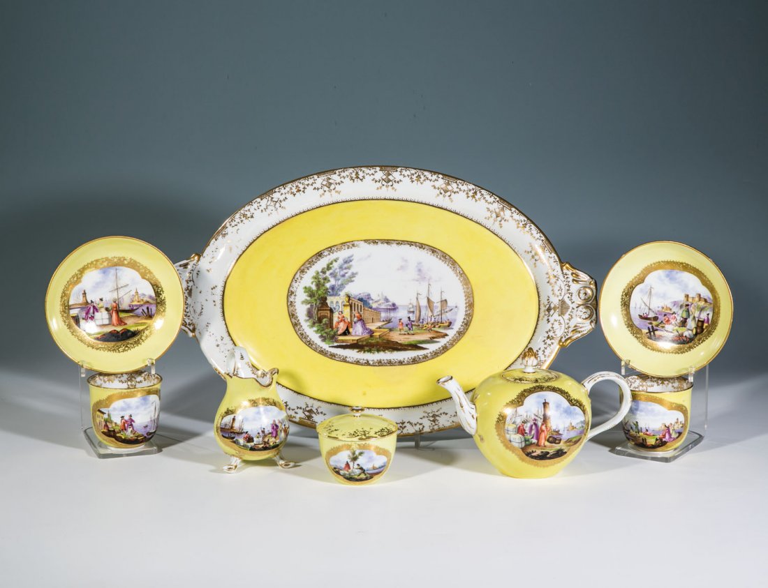 Tête-à-tête mit Kauffahrteiszenen: Tête-à-tête mit Kauffahrteiszenen Meissen, 19. Jh. Bestehend aus: Teekanne, Sahnekännchen, Zuckerdose, zwei Tassen mit Untertassen und Tablett. Auf Gelbfond ausgesparte, von Goldornamenten gerahmt