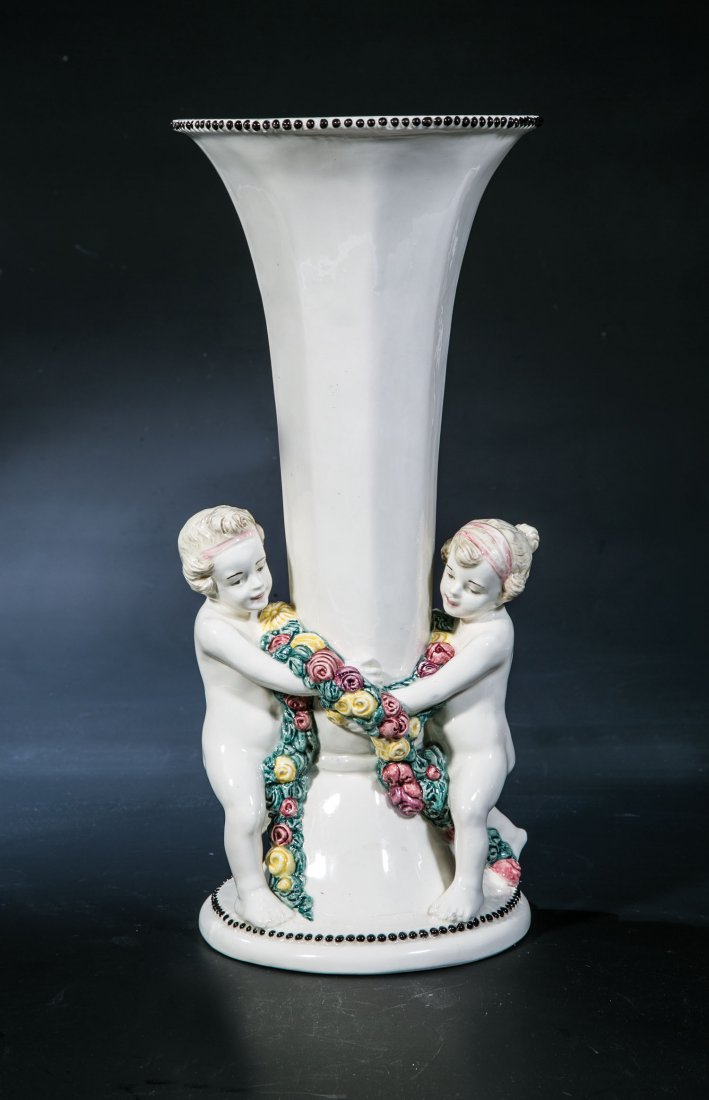 Vase mit Putten: Vase mit Putten Carl Klimt (Entwurf), Bernhard Bloch, Eichwald/Böhmen, um 1920 Steingut, bunte Unterglasurmalerei. Auf Rundsockel zwei plastische Putti, eine um die Vase geschwungene Blütengirlande
