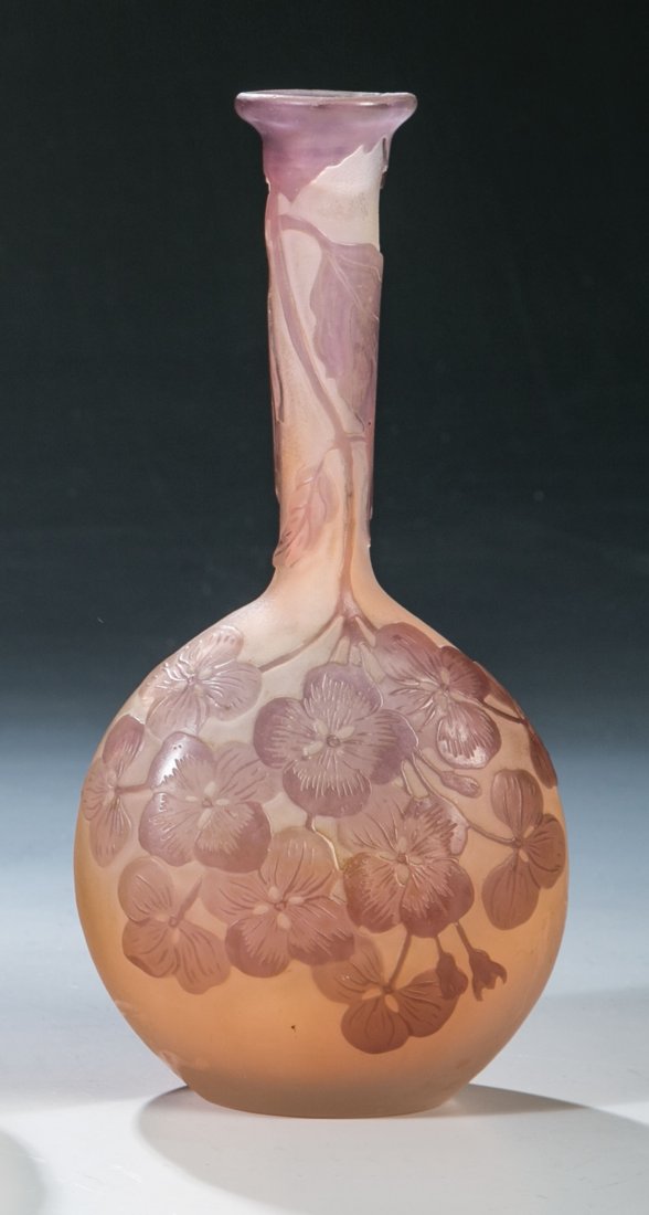Soliflore mit Hortensie: Soliflore mit Hortensie Emile Gallé, Nancy, um 1904 - 1906 Farbloses Glas, partiell lachsrosa unterfangen sowie violett überfangen. Umlaufend reliefiert geätzter Dekor: Hortensienblüten. Wandung i