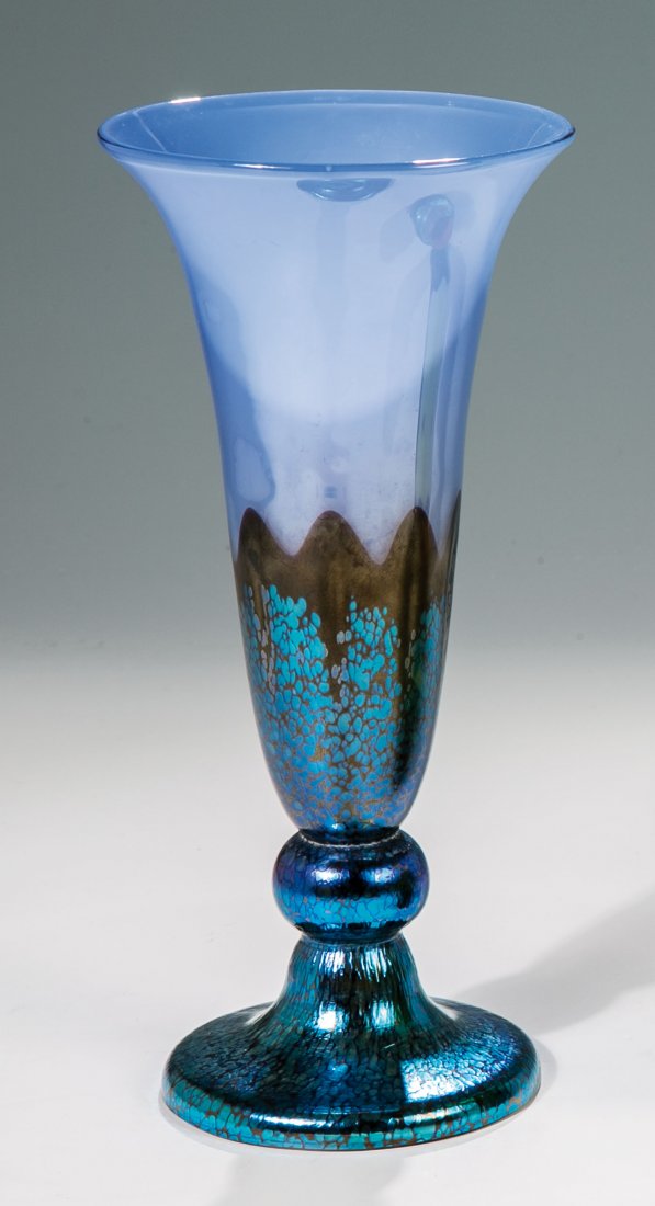 Fußvase ''Ausführung 226'': Fußvase ''Ausführung 226'' Loetz Wwe., Klostermühle, um 1925 Mit pastellblauem Opal unterfangenes farbloses Glas. Im unteren, wellenförmig begrenzten Bereich dunkelviolett überfangen, darauf silb