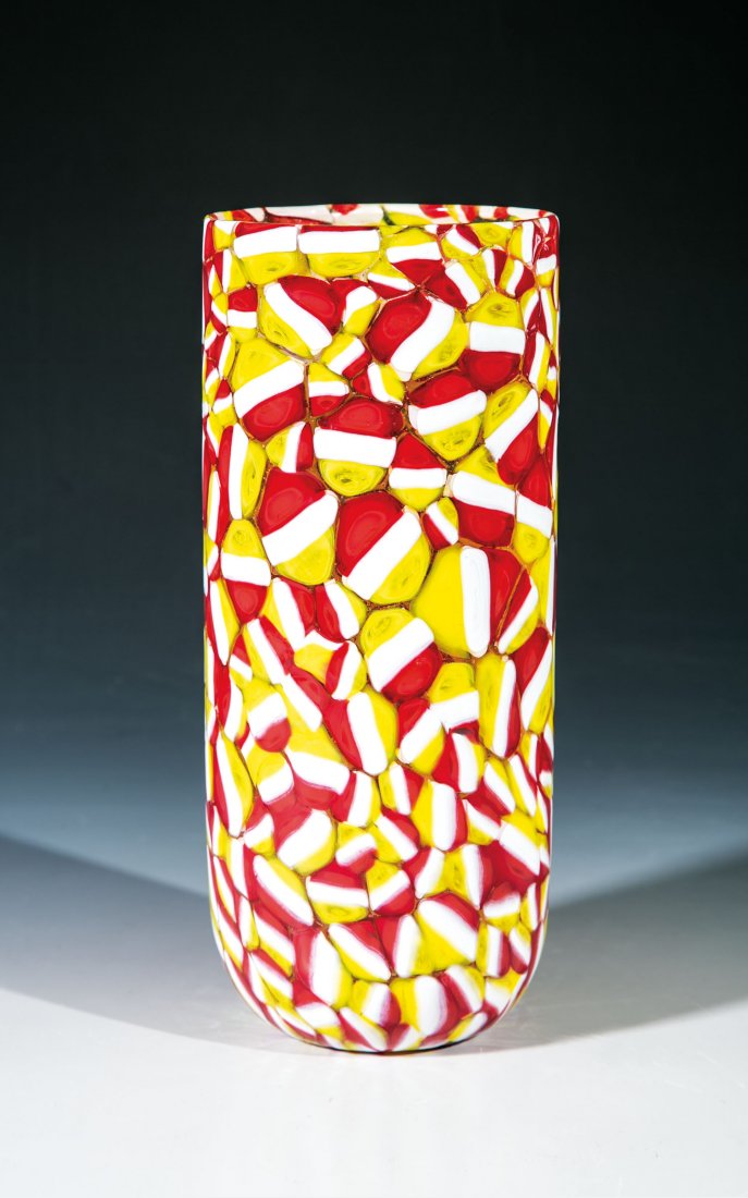 Zylindervase ''Murrine rosse - bianche -. gialle'': Zylindervase ''Murrine rosse - bianche -. gialle'' Ermanno Toso (Entwurf), Fratelli Toso, Murano, um 1955 Farbloses Glas mit eingeschmolzenen Murrine in Rot, Weiß und Gelb. Orig.- Klebeetikett der Ma