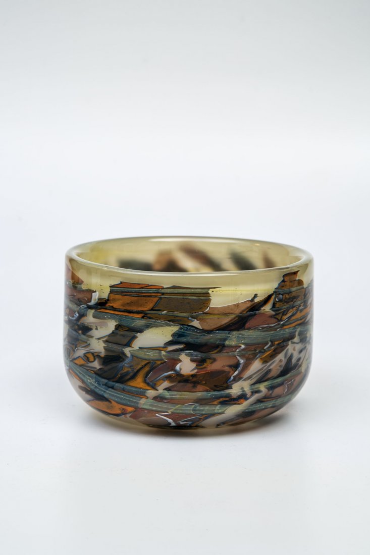 Schale: Schale Volkhard Precht, 1982 Farbloses Glas, mit beigegrauem Opal unterfangen. Mit blauen, weißen, braunen und orangefarbigen Glasfolieneinschmelzungen zwischen den Schichten. Unterseite in Diamantri