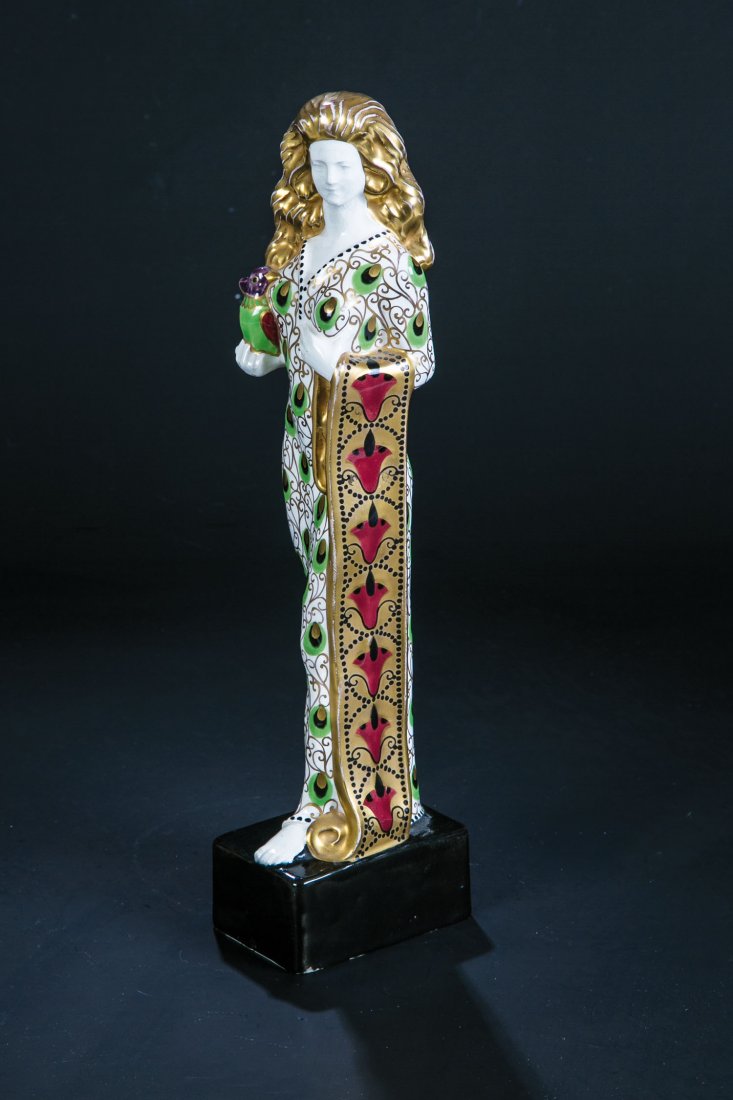 Seltene Modedame: Seltene Modedame Karl Klaus (Entwurf), Ernst Wahliss, Turn-Wien, um 1910 Serapis - Fayence. Auf hohem, schwarz glasiertem Rechtecksockel stehend, in der rechten Hand ein Vogel haltend. Reich staffiert