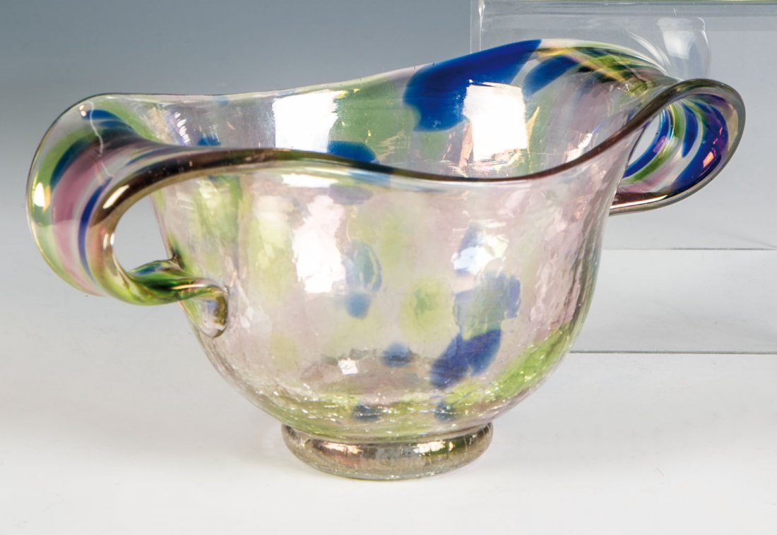Henkelvase: Henkelvase Loetz Wwe., Klostermühle, 1936 Farbloses, teils kräftig krakeliertes Glas mit eingeschmolzenen Farbtupfen in Blau, Rosaviolett und Hellgrün. Kräftig lüstriert. Mündung zu Henkeln zung