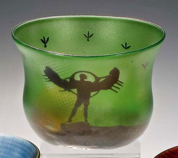 Vase: Bertil Vallien (Entwurf), Kosta. Farbloses Glas, innen hellgrün, partiell orange und schwarz unterfangen. Auf der Innenwandung in Sandstrahltechnik dekoriert. Außenwandung irisiert. Unterseite in Gr