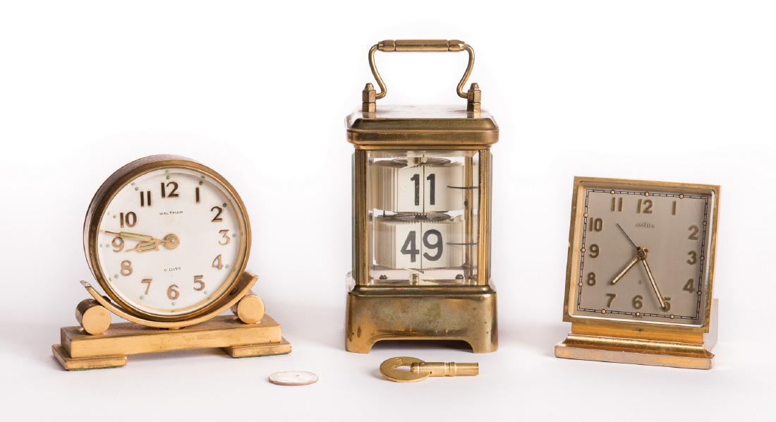 Lot of Three (3) 20th Century Clocks: 1st item: Plato flip ticket clock in rectangular glass case and brass base and lid with handle. Maker's and patent marks and key mechanism underside of base. Key is included. 6 1/4" H x 3" W x 2 5/8"