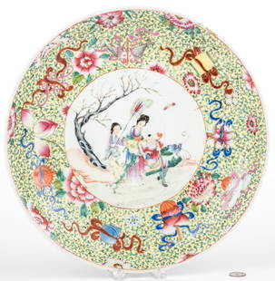 Chinese Famille Rose Porcelain Charger: Chinese Famille Rose porcelain charger with painted central landscape scene depicting a young boy and mother atop a foo dog/dragon with attendant holding a fan, enameled sgraffito yellow ground