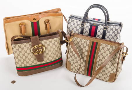 4 Vintage Gucci Handbags: Four (4) vintage Gucci handbags. 1st item: Navy monogram satchel with red/blue center stripe and rolled handles. 2nd item: Tan canvas tote with red/green center stripe and rolled handles. 3rd item: