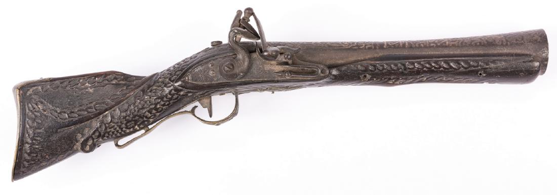 Middle Eastern Flintlock Blunderbuss Pistol: Middle Eastern flintlock blunderbuss pistol, unmarked. Mahogany stocks with carved garland swags. Flowering Kufic style script, embossed round barrel with flared muzzle (1 3/4" across), iron frame, br