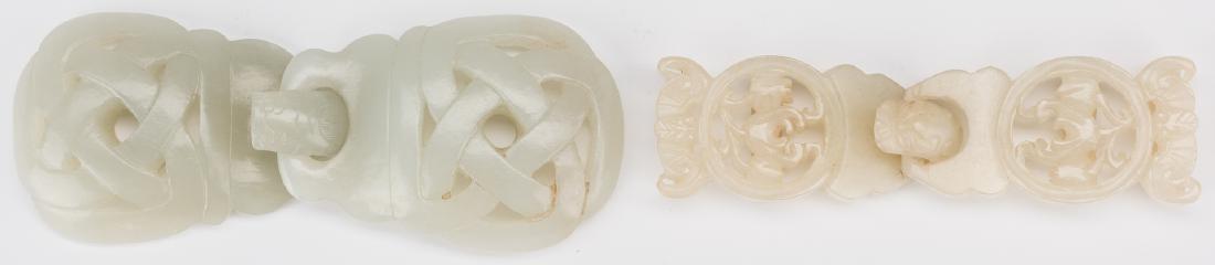 2 Chinese Celadon Jade Buckles: 1st item: Chinese carved pale celadon jade double belt buckle, pierced with knot design, chilong dragon hook. 2" H x 4 5/8" W. 2nd item: Chinese carved pale celadon jade double belt buckle, pierced