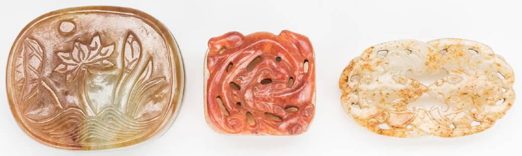 3 Chinese Celadon & Russet Jade Buckles: 1st item: Chinese carved celadon and russet jade buckle, square form with carved dragon decoration to the top. 1 3/8" H x 1 1/4" W. 2nd item: Chinese carved celadon and russet jade buckle, shaped