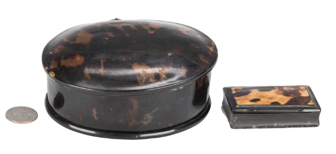 2 Tortoiseshell Boxes: Two (2) tortoiseshell hinged boxes, including one small rectangular lacquer snuff box with tortoiseshell lid and a larger oval tortoiseshell trinket box with silver hinge. 1 1/2" x 2 1/2" and 1 5/8" H