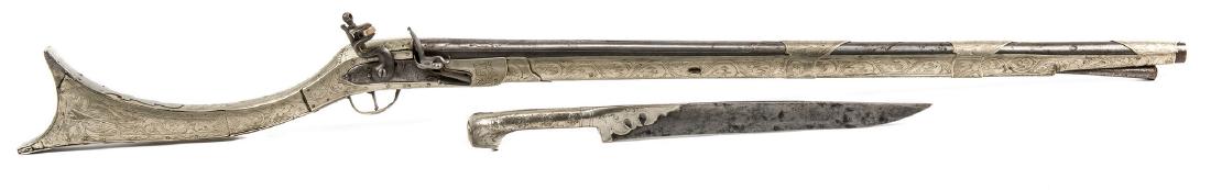 Turkish Flintlock Musketoon, .72 cal, with Dagger: Turkish Flintlock Musketoon, .72 caliber. Round barrel with body of gun covered in a heavily embellished Middle Eastern style tin overlay, Greek name inscribed to top of breech, plain silver butt plat