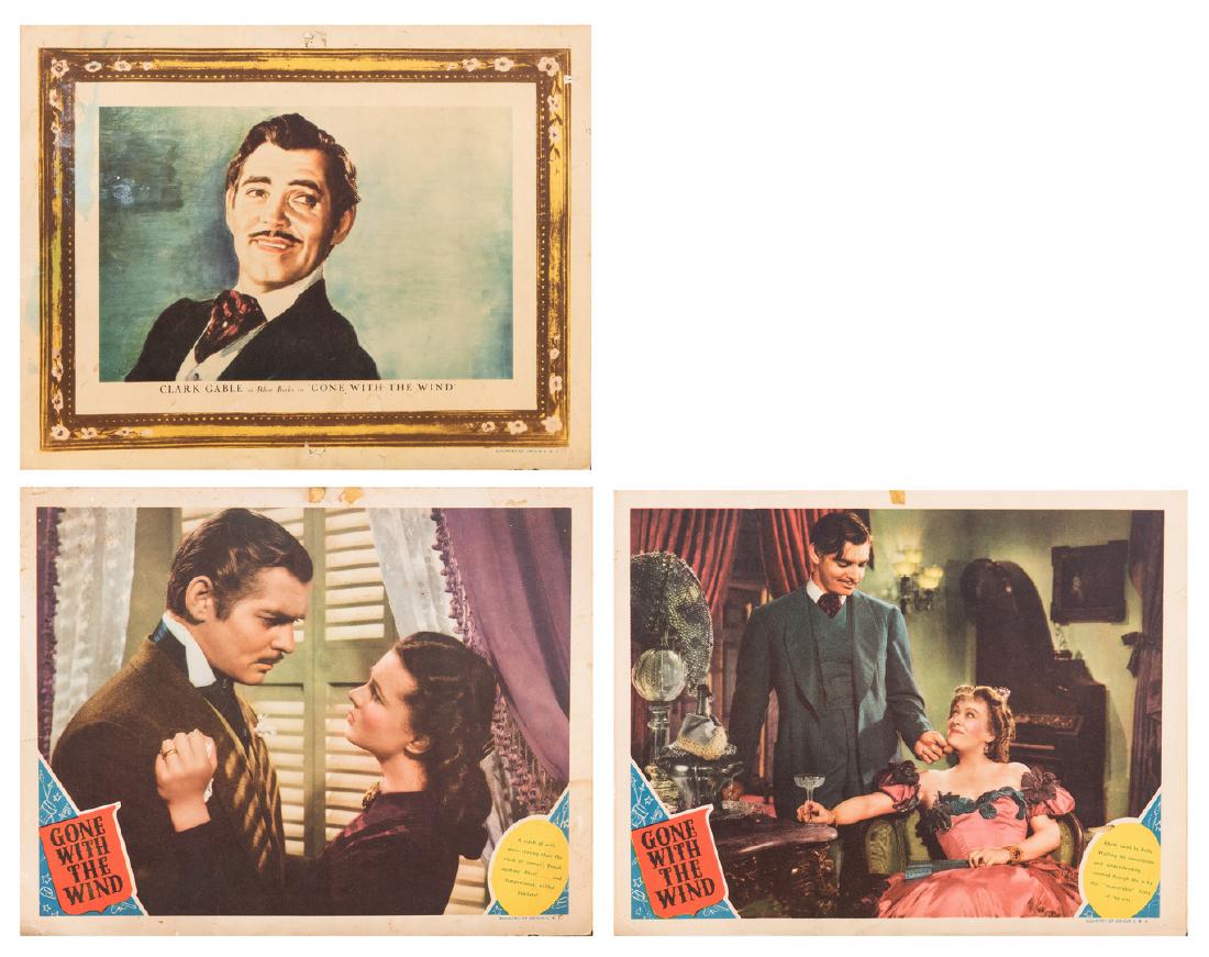 3 Gone With the Wind Lobby Cards: Three (3) MGM movie lobby cards for Gone With the Wind, 1939, plus later photograph, 4 items total. 1st item: Lobby card depicting Scarlett O'Hara embracing Rhett Butler, captioned: "A clash of wills 