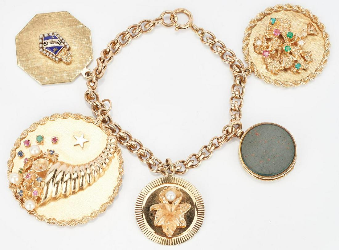14K Charm Bracelet, 5 charms: 14K yellow gold link bracelet with five (5) charms, including one (1) cornucopia disc charm with mount and gemstones, one (1) locket with coin and gemstone covers, one (1) tree of life disc charm with