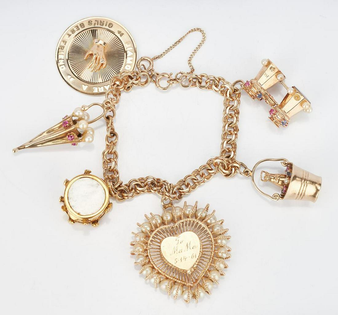 14k Charm Bracelet, 6 Charms: 14k yellow gold charm bracelet with six (6) various charms, including one (1) heart locket with pearl surround, one (1) drum with mother of pearl sides, one (1) champagne in bucket with gemstones, one