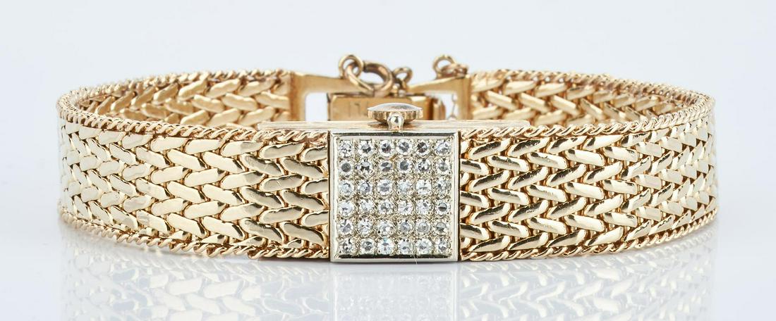 14K Ladies Geneva Hidden Face Watch: 14K Ladies Geneva Hidden Face watch with a flip top consisting of 36 single cut diamonds, approximately 0.25 carat total weight, VS1 clarity, and F color. Watch with champagne face and stylized number