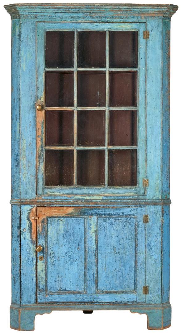 Southern/Mid-Atlantic Blue Painted Corner Cupboard: Southern or Mid-Atlantic two-part yellow pine corner cupboard with blue paint. Top with flat ogee cornice and dentil molding over one door having 12 glass panes that open to reveal 4 shelves, ogee med