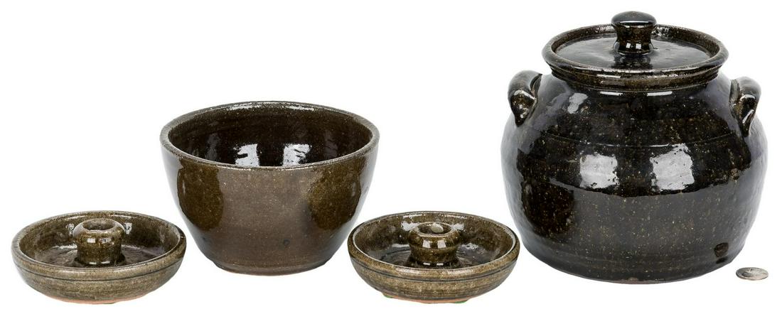 4 Pcs. Lanier Meaders & Arie Meaders Pottery: Grouping of four (4) Lanier Meaders and Arie Meaders pottery items including one (1) dark brown alkaline glazed covered bean pot (7" H x 7 3/4" dia.), one (1) pair of olive green alkaline glazed candl