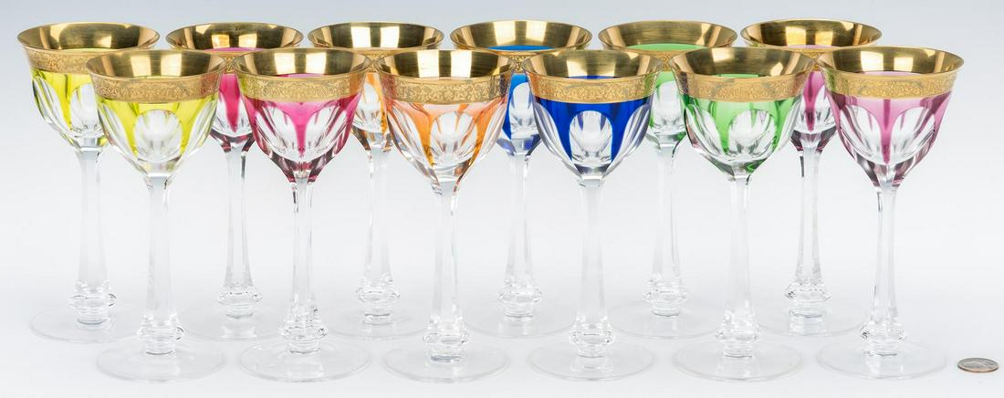 12 Signed Moser Colored Wine Glasses: Set of twelve (12) Bohemian wine glasses, signed Moser, heavy gilt encrusted rims over faceted bowls, colored glass cut to clear in shades of green, pink, blue, yellow, orange, and purple. Clear facet