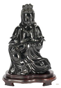 Monumental Black Jade or Hardstone Guanyin, 21" H: Large Chinese black jade or hardstone Guan Yin figure, depicted seated and holding a ruyi scepter, with custom carved and fitted hardwood stand. Dimensions of figure - 21" H x 13" W x 7 1/4" D (not