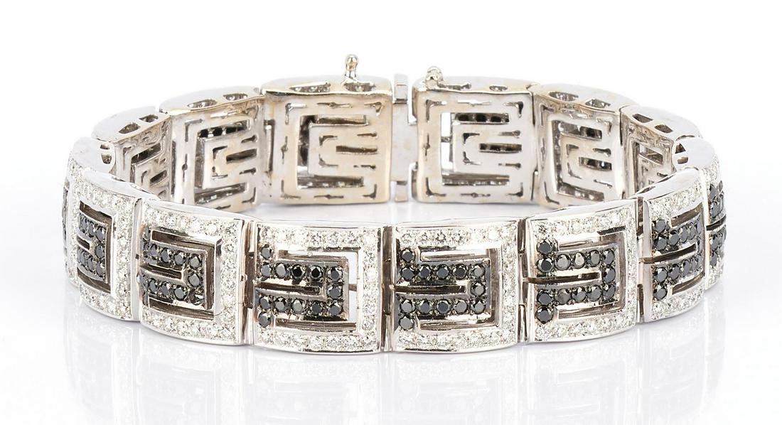 Ladies 14K White & Black Diamond Bracelet: One ladies 14k white gold square link bracelet, 12.2mm in width, with a total of 14 links, each set with 19 round brilliant white diamonds paved into the outer edge with a total of 13 single cut black