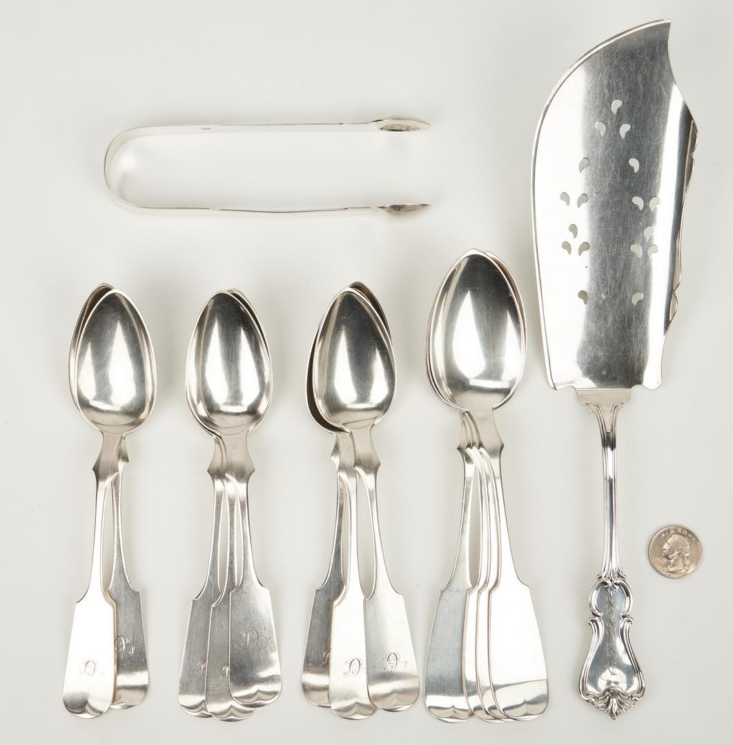 Coin silver fish slice and spoons plus English tongs: Group of 12 American coin silver flatware items, mid 19th century, and a pair of English sterling sugar tongs, 13 items total. Coin silver includes a fish slice with pierced and shaped blade, scroll a